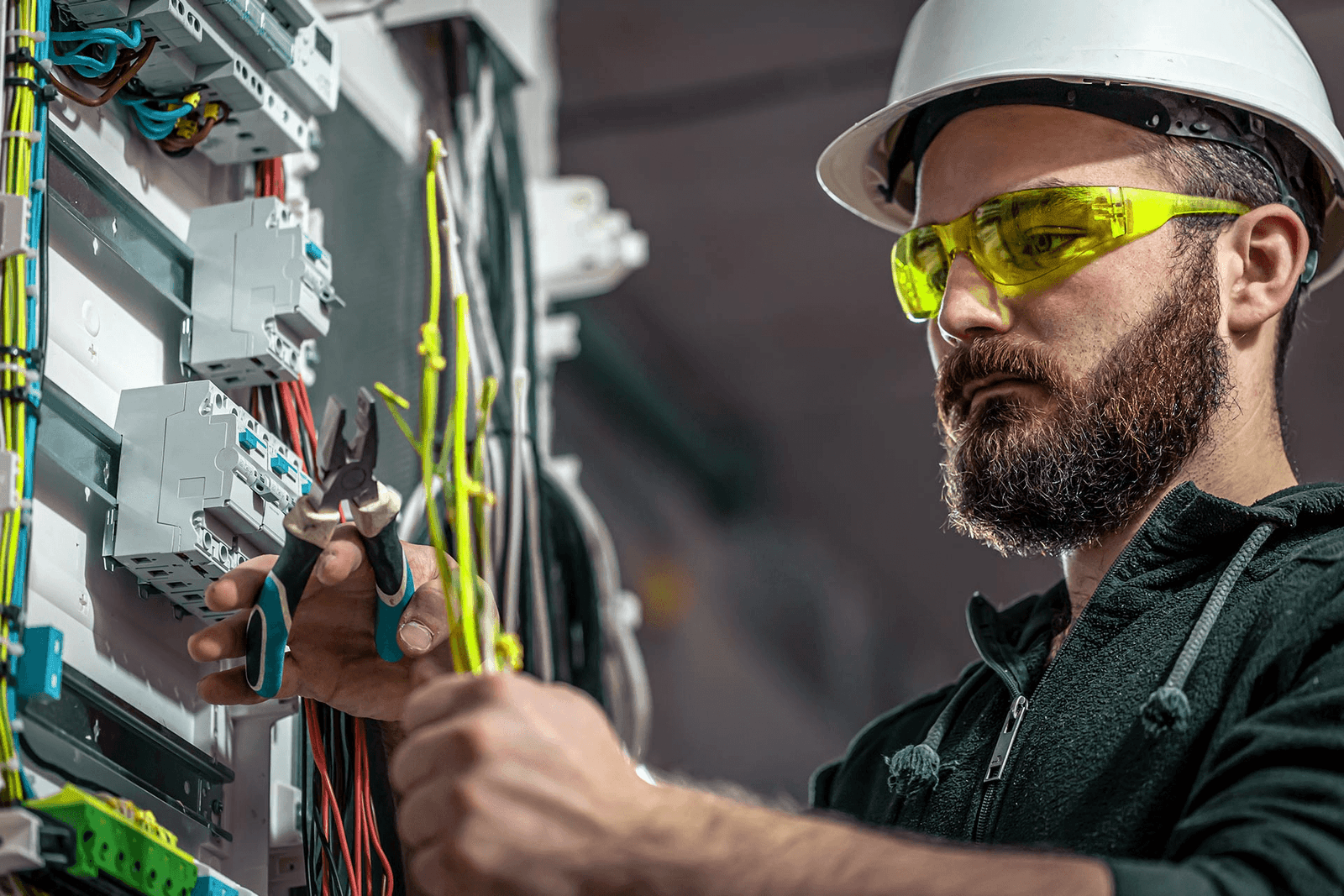 A Dynamic Electric crew member terminating wiring inside a commercial electrical panel